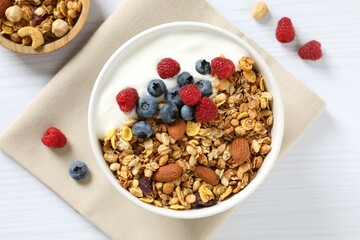 Delicious granola with berries and yogurt on a light background