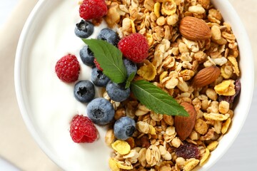Delicious granola with berries and yogurt on a light background