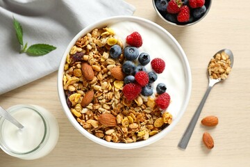 Delicious granola with berries and yogurt on a light background