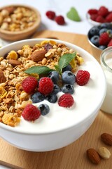Delicious granola with berries and yogurt on a light background