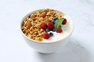 Delicious granola with berries and yogurt on a light background