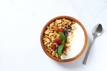 Delicious granola with berries and yogurt on a light background