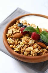 Delicious granola with berries and yogurt on a light background