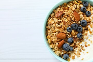 Delicious granola with berries and yogurt on a light background