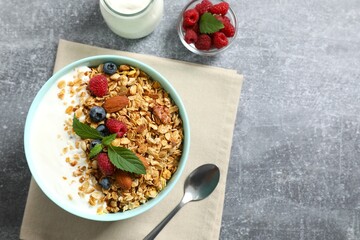 Delicious granola with berries and yogurt on a gray background