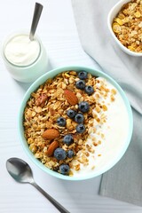 Delicious granola with berries and yogurt on a light background