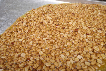 Roasted Peanuts in syrup made from sugar that has been simmered over heat until it almost becomes caramel in tray