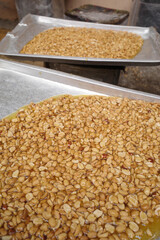 Close up Roasted Peanuts with syrup made from sugar that has been simmered over heat until it almost becomes caramel. 