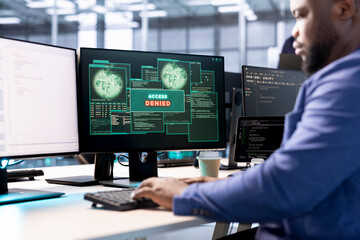 Software developer in data center getting access denied notification on PC screen, trying to access server files after they were locked by hacker using ransomware, receiving error