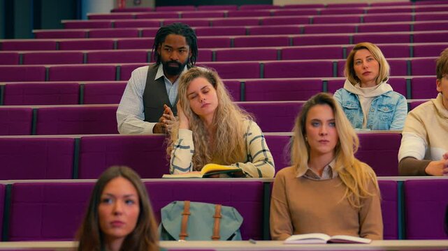 Multiethnic university students displaying varied engagement levels during classroom lecture, capturing diverse facial expressions and body language in slow motion cinematography