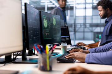 Programmers in server hub getting access granted notification on PC screen, managing to access server files after they were locked by hacker using ransomware, receiving aid from team members, close up
