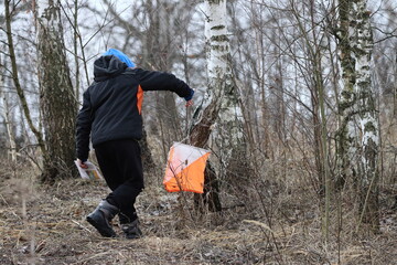 A boy training in orienteering at a checkpoint in a tree