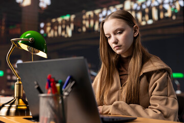 Fototapeta premium University student engrossed in research on foreign affairs via primary source materials and academic resources to create a perfect assignment. Girl working hard for a scholarship and certificate.