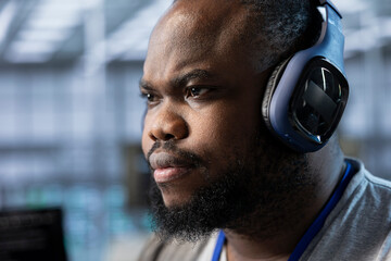 Close up of data center expert listening music and writing disaster recovery plans ensuring minimal...
