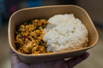 Rice topped with stir fried Thai basil with minced pork in paper brown box