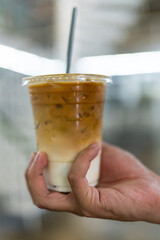 Ice latte coffee summer refreshing drink in hand. Cold brewed iced latte coffee