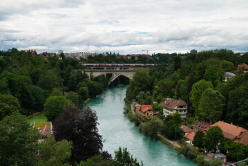 Fantastic views of the bridge and the Aar river surrounding the capital of Bern, Switzerland. Cloudy day in spring.