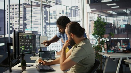 Manager correcting programmer mistakes while conducting code review to fix errors, identifying...