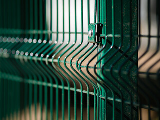 Selective focus on a column of metal mesh fence with rectangular cells