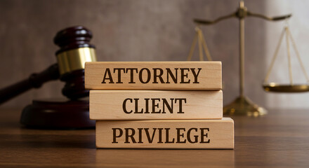 Three wooden blocks stacked vertically read "ATTORNEY CLIENT PRIVILEGE" in serif font. A blurred background with a gavel and scales highlights the legal theme, ideal for law-related content.







