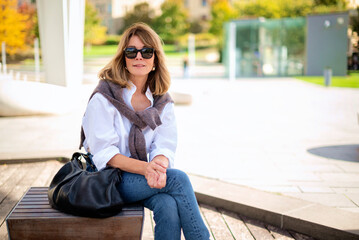 Blond haired caucasian woman sitting in the city park