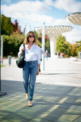 Fototapeta premium Blond haired woman walking in a city park