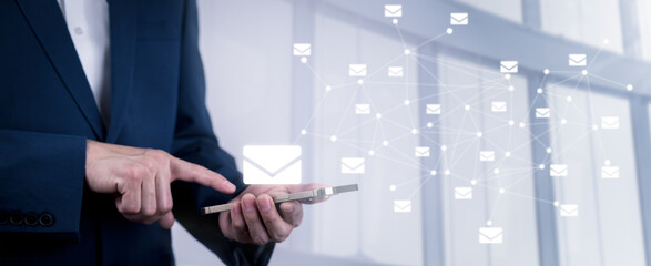 Businessman hand holding e-mail icon letter on a touch screen interface, virtual postal envelope,...