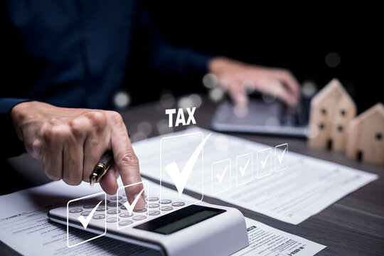 Hand using a laptop with TAX REFUND and refund tax of duty taxation business, graphs and chart being demonstrated on the screen media,  tablet pc and selecting tax refund, Saving tax for business