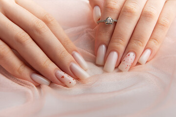 Female hands with fashionable ombre manicure on pink background