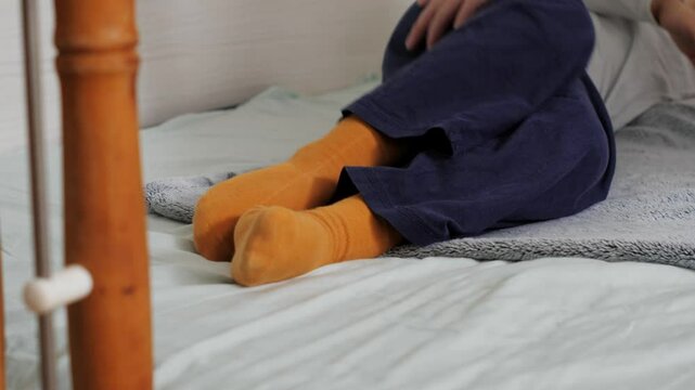 Mother rolling up her child into a soft blanket and unrolling him playfully