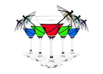 A group of 5 martini glasses filled, in three different colours, red, green and blue with an umbrella in each glass. This first glass is in focus and the others behind it are slightly out of focus.