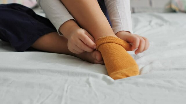 socks while sitting on bed, preparing for a restful night's sleep