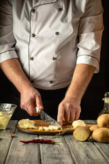 Hands expertly chop potatoes on a wooden surface, with nearby tools and ingredients. The warm ambiance of the rustic kitchen enhances the focused culinary process, highlighting a passion for cooking