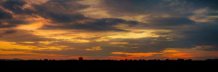 Stunning sunset over a vast landscape with vibrant orange and blue hues in the sky.