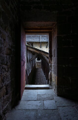 Fototapeta premium Wooden walkway inside a medieval fortress seen through a room with an open door in a castle in Carcassonne.