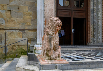 Bergamo, Italy. Lion statue front of Basilica of Santa Maria Maggiore in Citta Alta. Historical cathedral architecture of Old town.