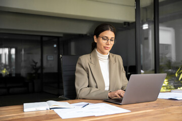 Smiling young middle eastern business woman specialist working focused on laptop computer. Middle...