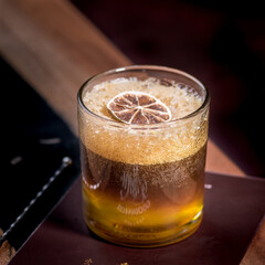 a glass of coffee tonic soda with dried orange fruit and decoration on top