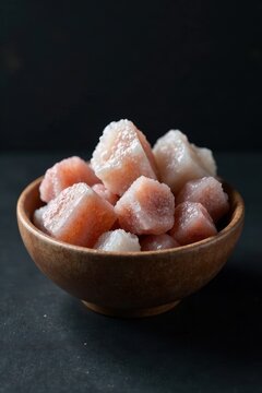 Raw zeolite mesolite stones in a bowl on a dark background, earthy tones, natural wonders, textures