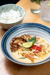 asian style lunch dish of protein tempeh chicken vegetable sauce rice side dish fresh lime garnish