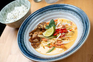 asian style lunch dish of protein tempeh chicken vegetable sauce rice side dish fresh lime garnish