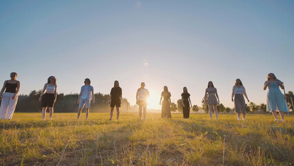 Young high school students gather in a field at sunset, savoring their summer vacation