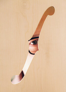Peeking through cutout in bass guitar workshop setting