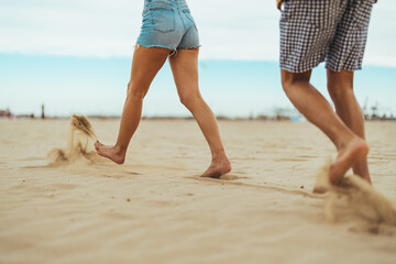 Couple Walking Barefoot on a Sandy Beach During a Sunny Day