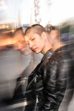 Urban portrait with blurred motion of shorthaired lesbian woman in black jacket