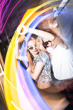 Vibrant party scene with dancing lesbian couple and colorful lights