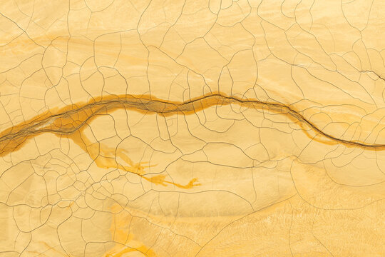 Golden mud and cracked earth texture for abstract backgrounds