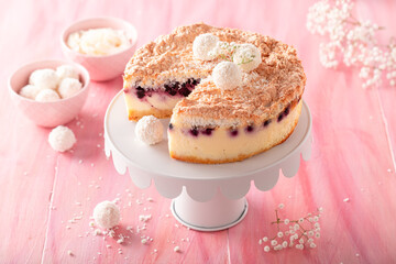 Tasty coconut cheesecake served on pink table.