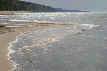 Pusta plaża nad morzem bałtyckim w zachodzącym jesiennym słońcu