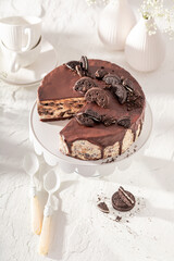 Homemade Cookie cheesecake with chocolate glaze on white.